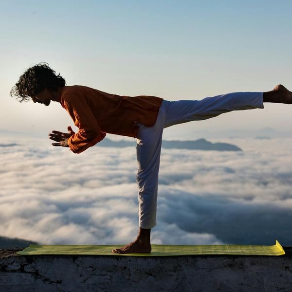 Silhouette of a man in a balanced gymnastic pose at sunrise.